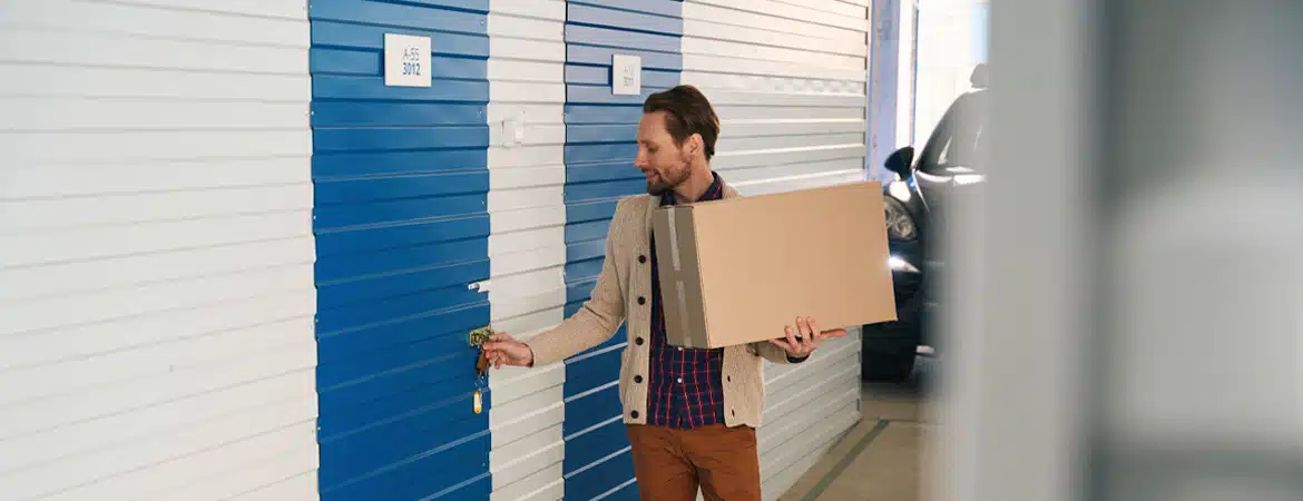 Young man with big cardboard boxes in self-storage